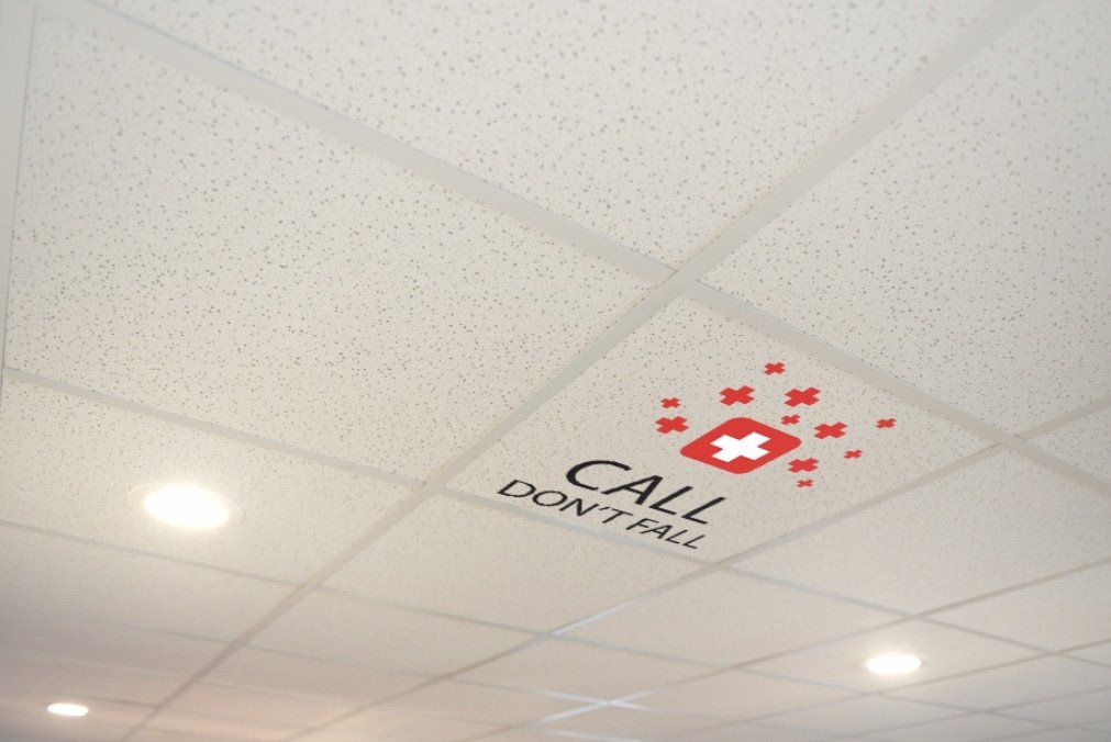 Printed hospital ceiling tile reading Call Don't Fall